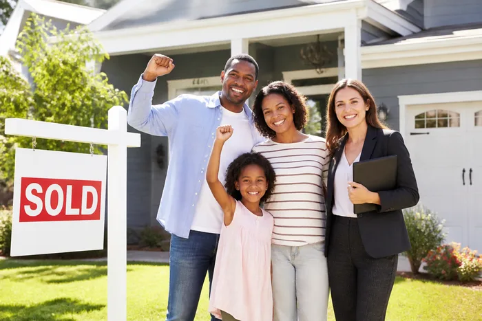 Family and agent celebrating sold home